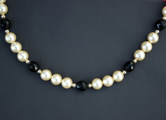 Old vintage necklace with pearl laying isolated on dark grey background,fashion flat lay with retro bijouterie,print as postcard for mothers and womens day,greeting card,free place for text,copy space