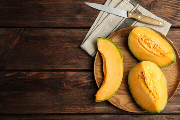 Tasty fresh cut melon on wooden table, flat lay. Space for text