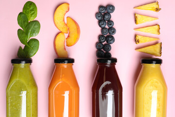 Flat lay composition with bottles of delicious juices and fresh ingredients on pink background