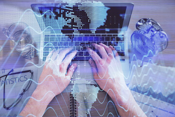 Multi exposure of man's hands typing over computer keyboard and forex graph hologram drawing. Top view. Financial markets concept.