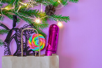 New year gift for adults. A paper bag from a sex shop. Vibrator and a mask. copy of space
