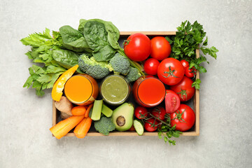 Delicious vegetable juices and fresh ingredients on light grey table, top view