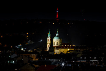 
illuminated church of St. Nicholas from the 17th century and light from street lights at night in the center of the old town of Prague
