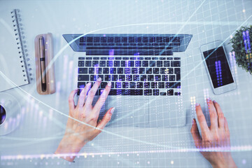 Double exposure of woman hands working on computer and forex chart hologram drawing. Top View. Financial analysis concept.