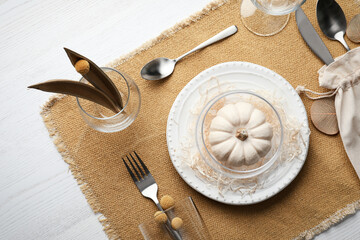 Fototapeta na wymiar Autumn table setting with pumpkin on white wooden background, flat lay