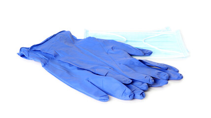 Medical gloves and protective face mask on white background