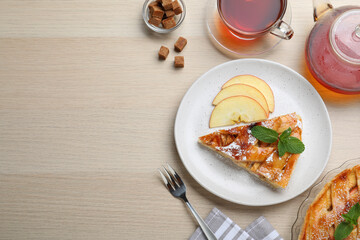 Slice of traditional apple pie served on wooden table, flat lay. Space for text
