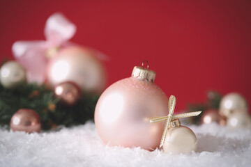 Fototapeta na wymiar Beautiful Christmas balls on snow against red background