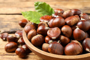 Fresh sweet edible chestnuts in bowl on table, closeup