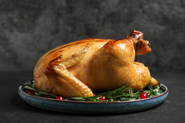 Delicious cooked turkey served with rosemary and cranberries on black table. Thanksgiving Day...