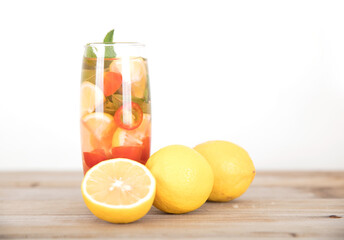 A cup of lemon mixed fruit tea and freshly cut lemon fruit