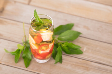 A cup of lemon mixed fruit tea and fresh mint leaves