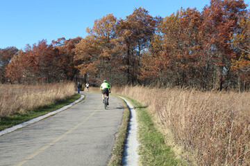 A cyclist, a walker, and  runner on the North Branch Trail at Miami Woods in Morton Grove, Illinois