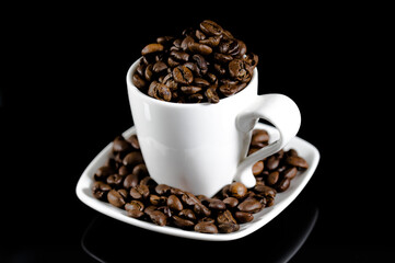 Espresso coffee mug on a black background full of coffee beans