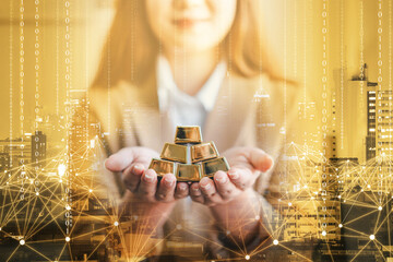 business woman holding gold bar stack in her hand