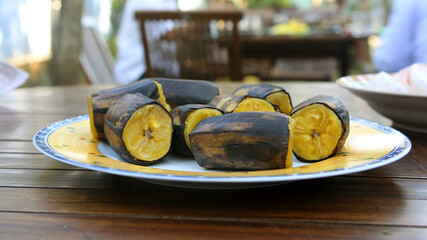 Boiled banana slices on a plate on a wooden table