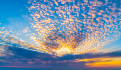  Dramatic sunset sky with orange colored clouds and sun.