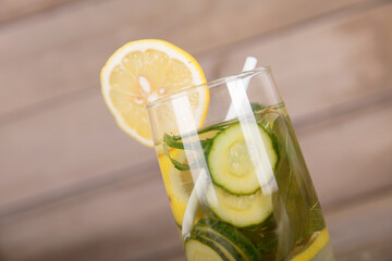 A glass of lemon cucumber water decorated with a slice of fresh lemon