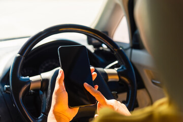 Naklejka premium Asian woman inside a car and using touch screen on mobile smartphone blank screen while driving the car in the morning on highway she find navigation location to go Transportation and vehicle concept