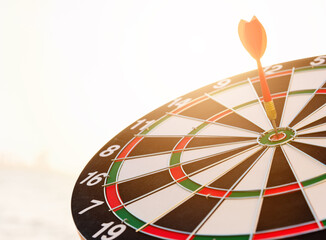 Dart arrow hitting to center on bullseye (bull's-eye) dartboard is the target of purpose challenge...