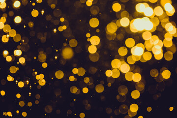 Fototapeta na wymiar Gold bokeh from light in water with black background