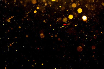 Fototapeta na wymiar Gold bokeh from light in water with black background