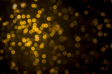 Gold bokeh from light in water with black background