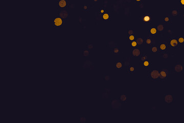 Gold bokeh from light in water with black background