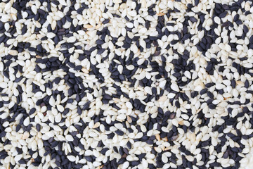 Black sesame seeds mixed with sesame background.