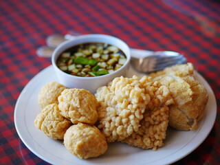Indonesian Food empek-empek (savory fish cake dish) from Palembang, South Sumatra, Indonesia served in plate. Served in sweet and sour sauce with mashed ebi shrimp, dice cucumbers
