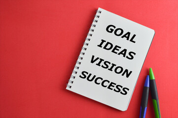 Top view of pens and notebook written with text "Goal, Ideas, Vision, Success". Business and Education concept.