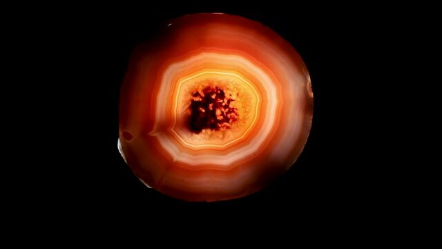 Backlit Brazilian agate showed dense layers of multicolored rings.  Mineral specimen.
