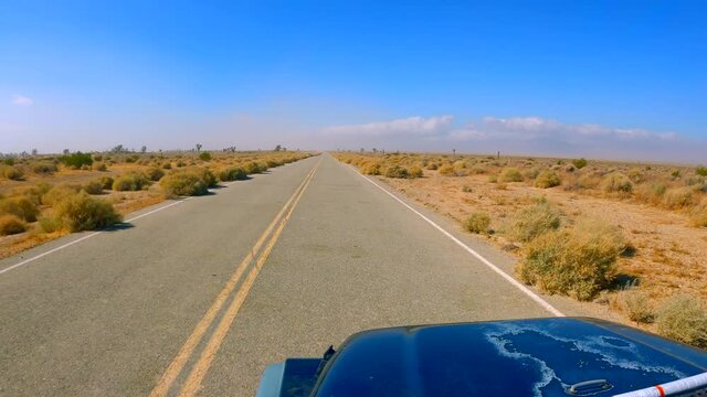 Driving along a road going through the Mojave Desert landscape in Southern California