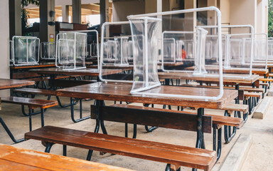 Group of plastic partition setting on table in canteen for reduce and protection the COVID-19 virus spreads in pandemic. Social distancing concept.