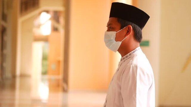 Muslim Indonesian young man praying for Allah at the mosque. Religious muslim Asia man praying inside the mosque.
