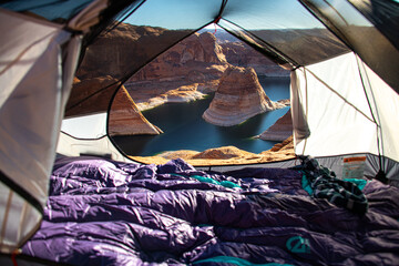 View of Reflection Canyon in Utah through a tent with sleeping bags in it. This camping area overlooked the rock formation with the river and canyon walls
