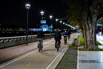 People riding bicycles on bike paths at night. North waterfront, Buenos Aires, Argentina.