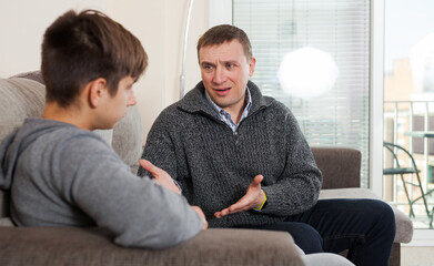 Dissatisfied father scolds young son. High quality photo