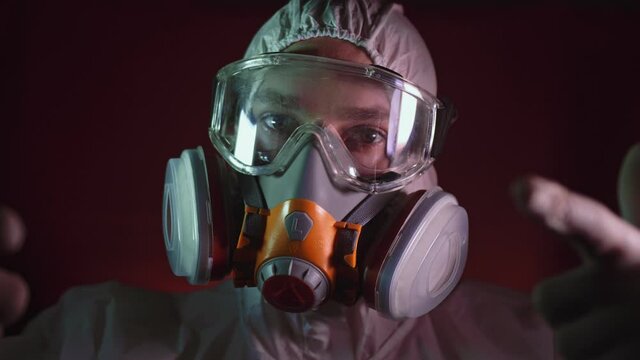 Man in protective costume suit, gas protect medical antibacterial antiviral spray paint mask. Doctor health worker in respirator. Concept health virus coronavirus epidemic. Radiation Nuclear war.