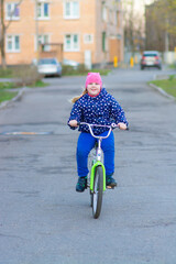 A girl rides a Bicycle on the street and enjoys the good weather.