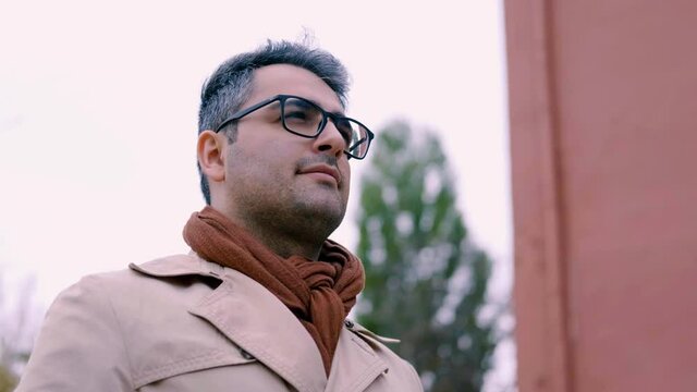 The handsome man of Oriental appearance, a poet and artist with glasses. Intellectual. The camera rotation around the guy 360 degrees. Slow motion