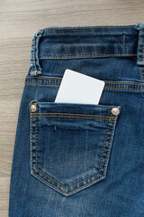 empty white paper card is in the back pocket of blue jeans, full frame