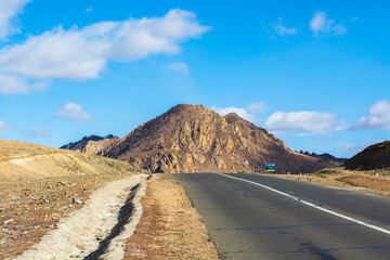 A beautiful mountain road without people and cars on a sunny day, a stunning landscape and an exciting way for car enthusiasts. The road on which you want to go forever, Mongolia