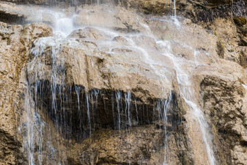 Close-up view of the waterfall streams flowing down the rocks of the mountain