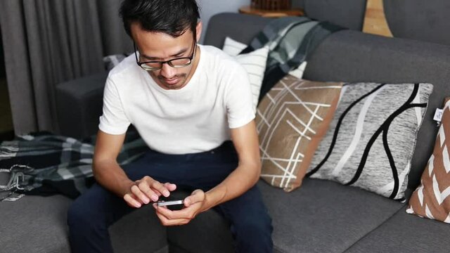 Young man using smartphone with social media network during stay at home, connection, communication and work from home concept	
