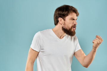 Man gestures with his hands emotions displeasure white t-shirt blue background