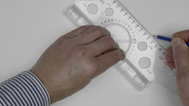 An engineer (apprentice, apprentice, designer) easily draw parallel lines on a white sheet with a transparent roller ruler