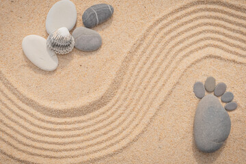 Fototapeta na wymiar Arrière-plan grains de sable de mer, sable fin de plage avec coquillages et galets. Emplacement pour texte. Galets en forme de petit pied pour annoncer une naissance.