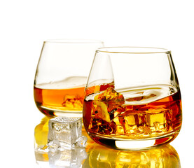 Two glasses of scotch whiskey and ice on a white background