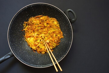 Above shot of pan with vegetables against black background